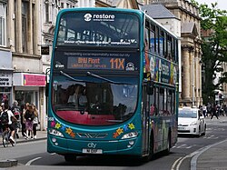 The 2022 subject of the 'Brand the Bus' competition, the Oxford Bus Company's 368, a 2013 Volvo B5LH Wright Gemini 2 wrapped in a livery advertising the 'Restore' mental health charity, on the High Street on a 11X express to Oxford's BMW plant.