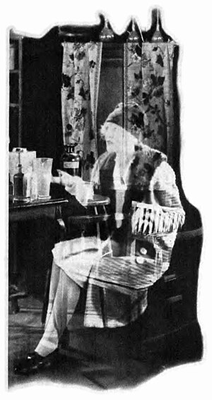 A ghostly woman sits at a vanity, reaching out and imploring a listener just out of frame.