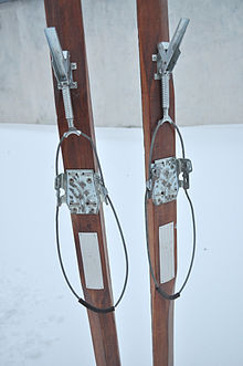 A typical late-model cable binding. The boot is inserted into the metal plate, and held down by a leather strap (missing). The cable is then lifted over the heel of the boot, and pulled forward by the lever at the top of the image. The spring keeps constant tension as the boot moves up and down through the striding motion. Skidbindning.JPG