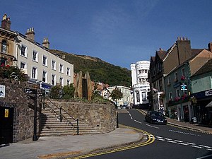 Vista do cruzamento da Church Street e Bellevue Terrace em Great Malvern, o centro da cidade de Malvern, com North Hill em segundo plano, e o grupo de esculturas Elgar e Enigma à esquerda.