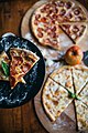 Two different slices of pizza at a restaurant closeup. (49134666467).jpg