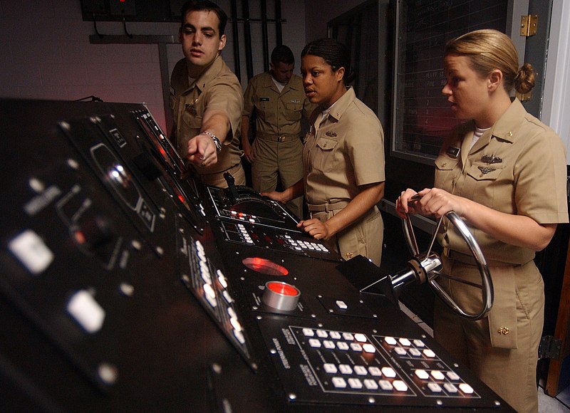 File:US Navy 050517-N-2000D-032 Lt. j.g. Mike Benny, left, navigation instructor at the Naval Science Institute, explains some of the components of the helmsman console.jpg