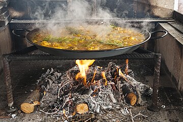 Paella being cooked on a wood fire