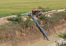 Thai model 8 inch x 20 foot long axial flow pump powered by 12 horsepower two-wheel tractor lifting water from an irrigation canal into nearby rice fields via plastic flexible delivery pipe 2011MarchScottNCraig 207 1.jpg