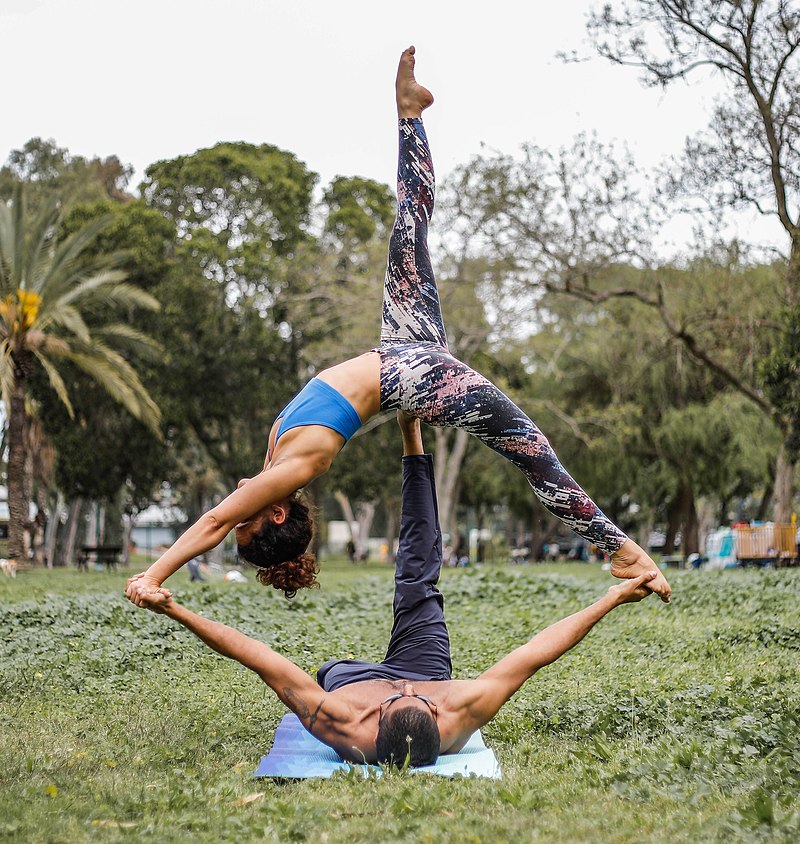 Flexible Woman And Man Performing Acro Yoga Pose