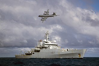 Plane flies over ship