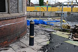 A bollard situated near broken roof tiles and glass from the Castle Buildings in Kingston upon Hull.