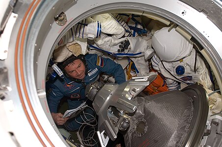 L'équipage de Soyouz ouvre l'écoutille du module orbital après l'amarrage. On distingue le système d'amarrage sonde-cone