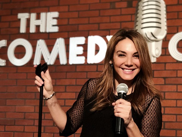 Jill-Michele Meleán at the Comedy Club in Pechanga, in front of a redbrick wall