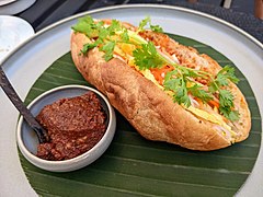 Khao chi pâté (Lao-style banh mi) with a spicy sauce on the side