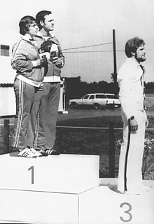 In 1976, Margaret Murdock captured the silver in the three positions shooting event. Lanny Bassham and Murdock tied for the first place, but Murdock was placed second after review of the targets. Bassham suggested that two gold medals be given, and after this request was declined, asked Murdock to share the top step with him at the award ceremony. Women had no separate shooting events at the time and were allowed to compete with men. Murdock became the first woman to win an Olympic medal in shooting. Margaret Murdock, Lanny Bassham and Werner Seibold 1976.jpg