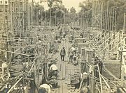 De vorderende metselwerkzaamheden. Linksboven in de foto is het Hoofdadministratiegebouw II zichtbaar achter de steigerdelen.