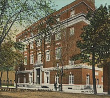 Postcard image of the building's exterior in red bricks and white trim around the doors and windows