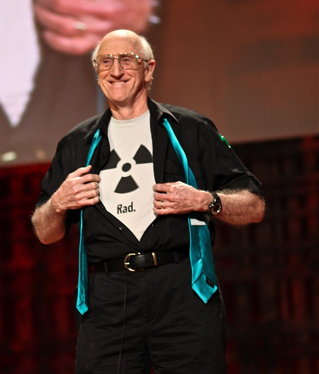 Stewart Brand wearing a shirt bearing the radioactive trefoil symbol with the caption «Rad.»