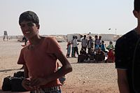 Refugees waiting to leave the camp (9638089020).jpg