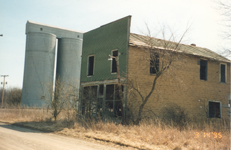 An abandoned building and grain silos in Sloan, Indiana Sloan, Indiana building and silos.png
