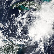 Ein Satellitenbild einer Ansammlung von Stürmen, die schwach um ein gemeinsames Zentrum kreisen.