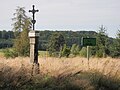 Kříž a pamětní cedule na východním okraji zaniklé vsi