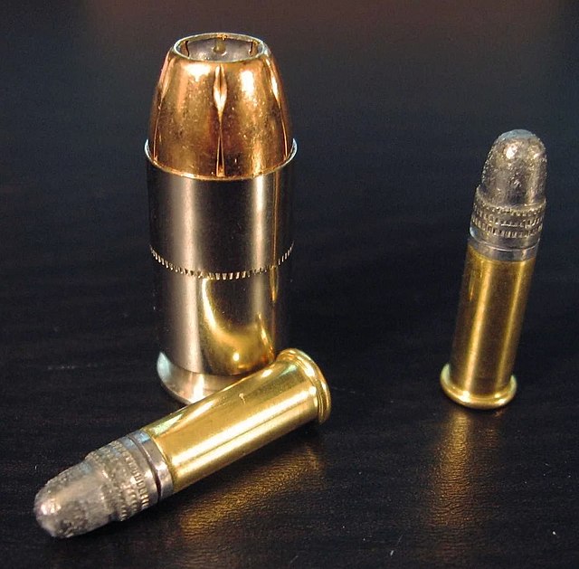 A 45 ACP hollowpoint (Federal HST) with two 22 LR cartridges for comparison