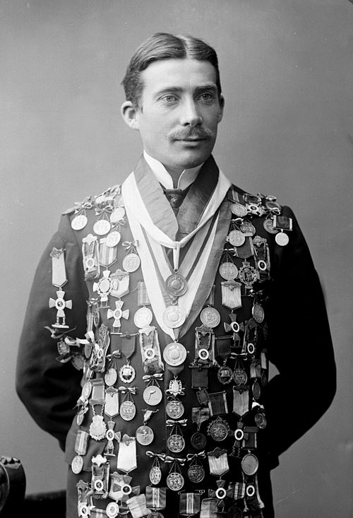 Skøyteløperen Rudolf Gundersen poserer med medaljer  Foto: Gustav Borgen (1865–1926)