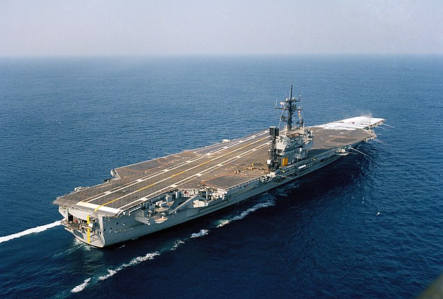 An aerial starboard quarter view of the aircraft carrier USS John F. Kennedy (CV-67), which was the last US Navy aircraft carrier to use conventional 