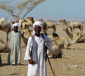 رجل بدوي في صحراء السودان في لباسه التقليدي الأبيض.