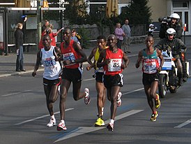 Хайле Гебресселассие (в жёлтом) с группой пейсмейкеров на пути к мировому рекорду в 2008 году