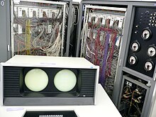 CDC 6600 computer. Display console shown in the foreground, main system cabinet in background, with memory/logic/wiring to the left and middle, and power/cooling generation and control to the right. CDC 6600 introduced in 1964.jpg