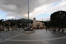 The Adjuntas barrio-pueblo plaza with its Catholic church, seen in the background, is where the Adjuntas' annual patron saint festival is held. Central Square, Adjuntas, Puerto Rico.jpg