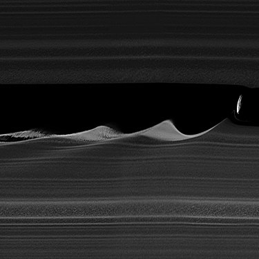 Радијално растегнат (4x) приказ на брановите на работ на Килеровиот јаз предизвикани од Дафнис.