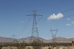Path 27 may be identified by its uniquely-designed steel lattice pylons and two conductors. The tower's height, insulation, and separation of conductors and their thickness meet the specifics for a 500-kV circuit. Compare to a lower-voltage, conventional three-phase power line on the right. DcOver247.jpg