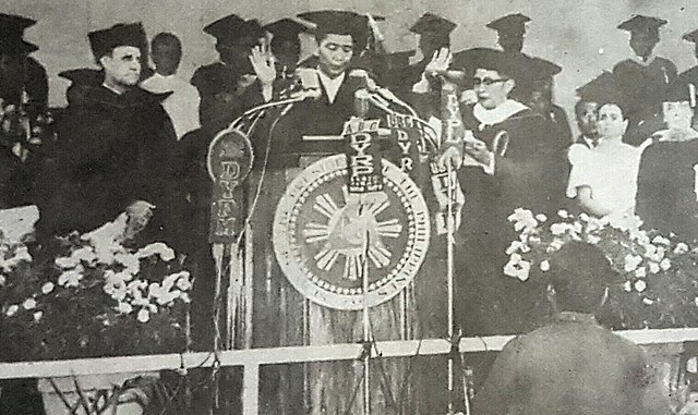 Ferdinand Marcos being conferred with a Doctor Laws, honoris causa degree during the investiture of the first Filipino president of Central Philippine