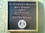 Plaque on the pedestal of Mary Brogger's Haymarket Memorial sculpture. Note that Mayor Richard M. Daley's name has been vandalized and the Seal of the City of Chicago[84] has been painted over by hand with a "circle-A," a symbol of anarchism.