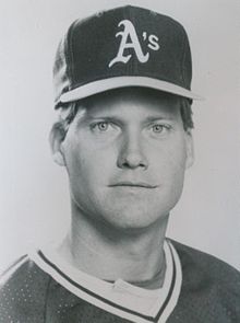 A man in a dark baseball uniform and cap