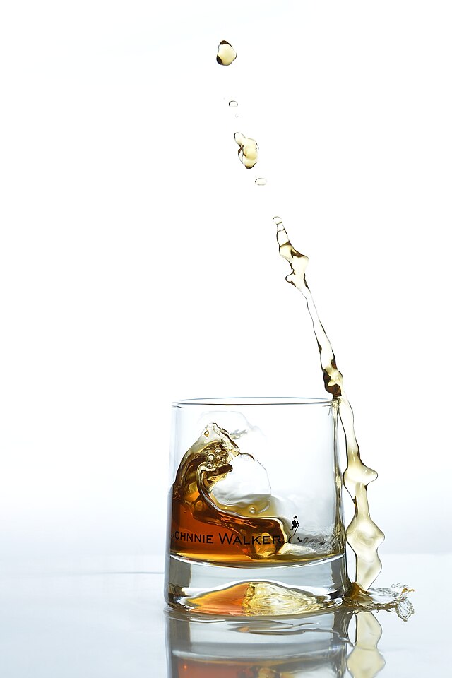 Скоростная фотография выплёскивающегося из стакана виски