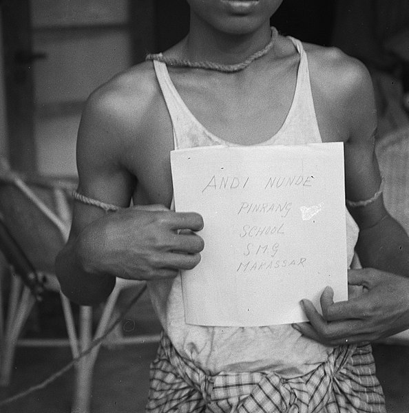 File:Jongen met touw om nek en armen houdt een papier voor zijn borst met de tekst…, Bestanddeelnr 997.jpg