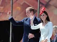 Catherine dan William melambaikan tangan. Dia mengenakan topi merah dan gaun putih beserta bros berlian berbentuk daun maple.