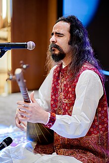 close-up of Kayhan Kalhor wearing a black t-shirt, looking right of camera with set expression