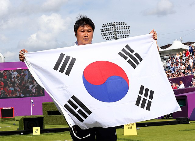 Gold medallist Oh Jin-hyek holds the flag of South Korea following his victory