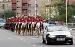 A mounted cavalry unit of the guard being escorted by local police during a procession to Naadam.