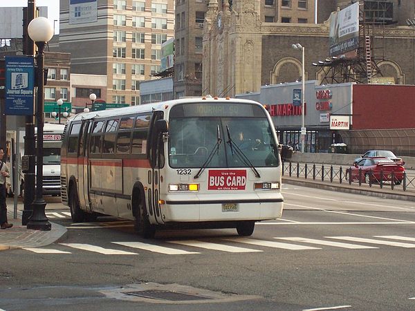 Bus at Journal Square before turning into Pavonia Avenue and entrance to bus platforms, followed by a guagua (minibus), which also serves the region