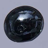 A bead of osmium, about 0.5 cm in diameter, displaying the metal's reflectivity