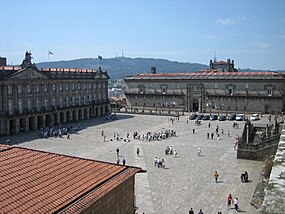 A Praça do Obradoiro vista da varanda sudoeste da Catedral de Santiago de Compostela; ao fundo, à direita: Hospital dos Reis Católicos; à esquerda: Paço de Raxoi; em primeiro plano, à esquerda: parte do telhado do Colégio de São Jerónimo; à direita vê-se as escadaria que dá acesso à catedral