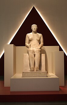 Statue of Hemiunu, vizier and designer of Khufu's pyramid, at the Roemer- und Pelizaeus-Museum Hildesheim, Germany. His feet rest on columns of hieroglyphs, painted in yellow, red, brown, and black. RPM Agypten 006.jpg