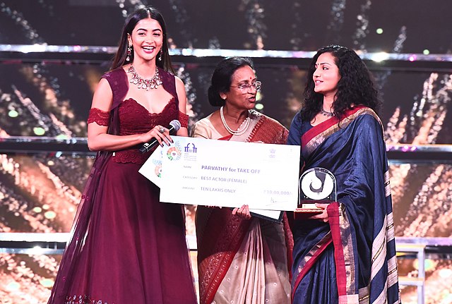 The Minister of Tourism, Uttar Pradesh, Rita Bahuguna Joshi along with actress Pooja Hegde presenting the Silver Peacock Award for the Best Actor (Fem