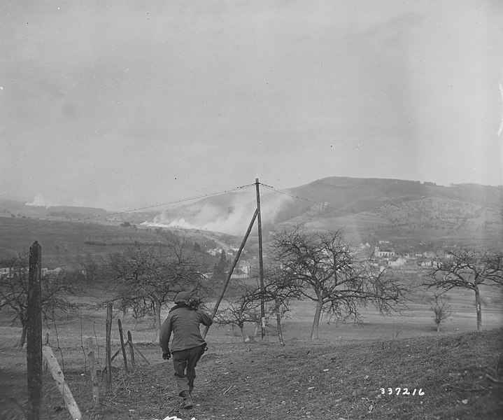 File:SC 337216 - Signal Corps cameraman S Sgt. Raymond Graham, Los Angeles, Calif., carries his motion picture newsreel camera toward Holstheim, Germany. (52204426515).jpg