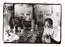 A resident in San Francisco serves tea to a visitor in 1977. SF Chinatown resident serving tea, 1977.jpg