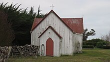 Eine hölzerne Kirche in einer Graslandumgebung