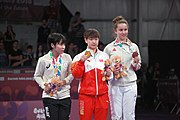 Deutsch: Tischtennis bei den Olympischen Jugend-Sommerspielen 2018: Tag 4, 10. Oktober 2018, Mädchen-Einzel, Siegerehrung - Gold: Yingsha Sun (CHN), Silber: Miu Hirano (JPN), Bronze:Andreea Dragoman (ROU)); Medaillen überreicht durch IOC-Mitglied Ching-kuo Wu (TPE), Maskottchen überreicht durch ITTF-Vize-Präsident Masahiro Maehara (JPN) English: Fencing at the 2018 Summer Youth Olympics at 10 October 2018 – Girls' single medail ceremony – Gold: Yingsha Sun (CHN), Silber: Miu Hirano (JPN), Bronze:Andreea Dragoman (ROU)); Medal presenter: IOC member Ching-kuo Wu (TPE), Mascot presenter: Vice-President Executive of the ITTF Masahiro Maehara (JPN)