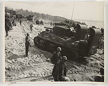 M4 Sherman tanks and other vehicles deploy inland. Extended exhaust stacks allow them to operate in shallow water. Tanks on beach tinian lg.jpg